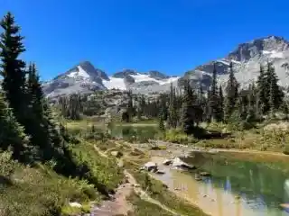 A trail past an alpine lake at Semaphore Lakes Trail near Pemberton, BC