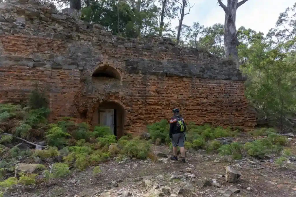 A man walks past brick, convict-era ruins in Tasmania