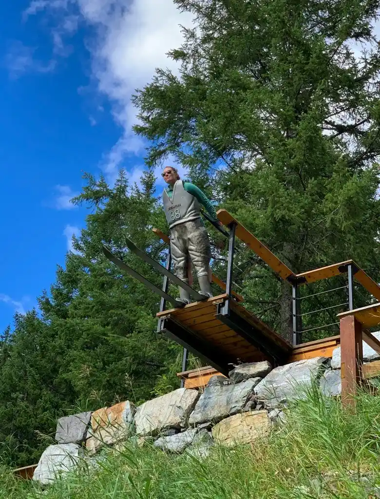 A woman poses at the Nels Knickers sculpture in Mount Revelstoke National Park
