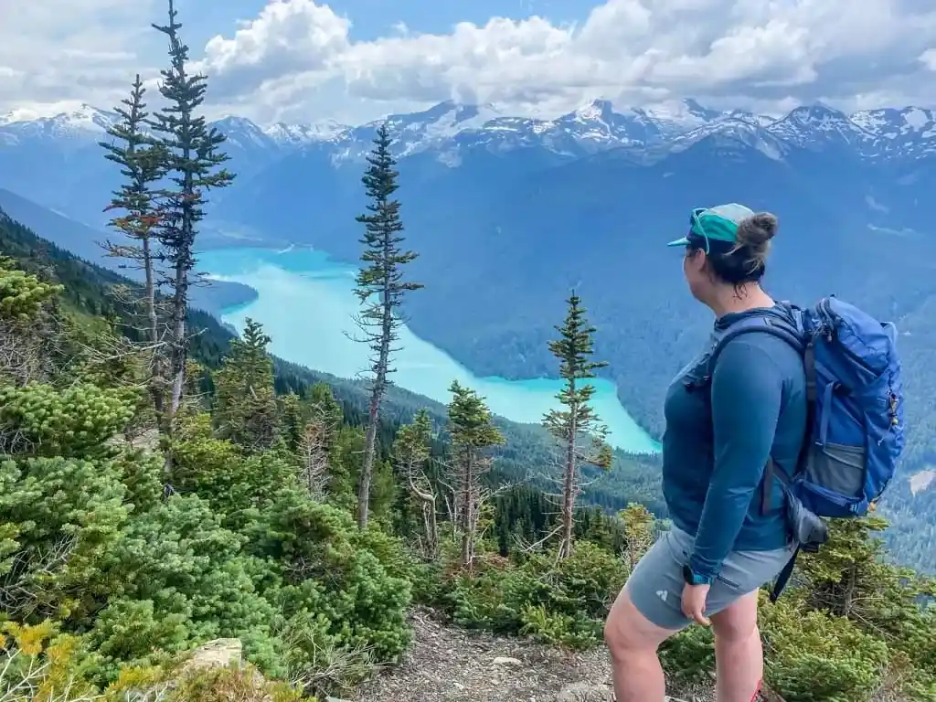 A hiker looks down at a lake from the top of the High Note Trail in Whistler