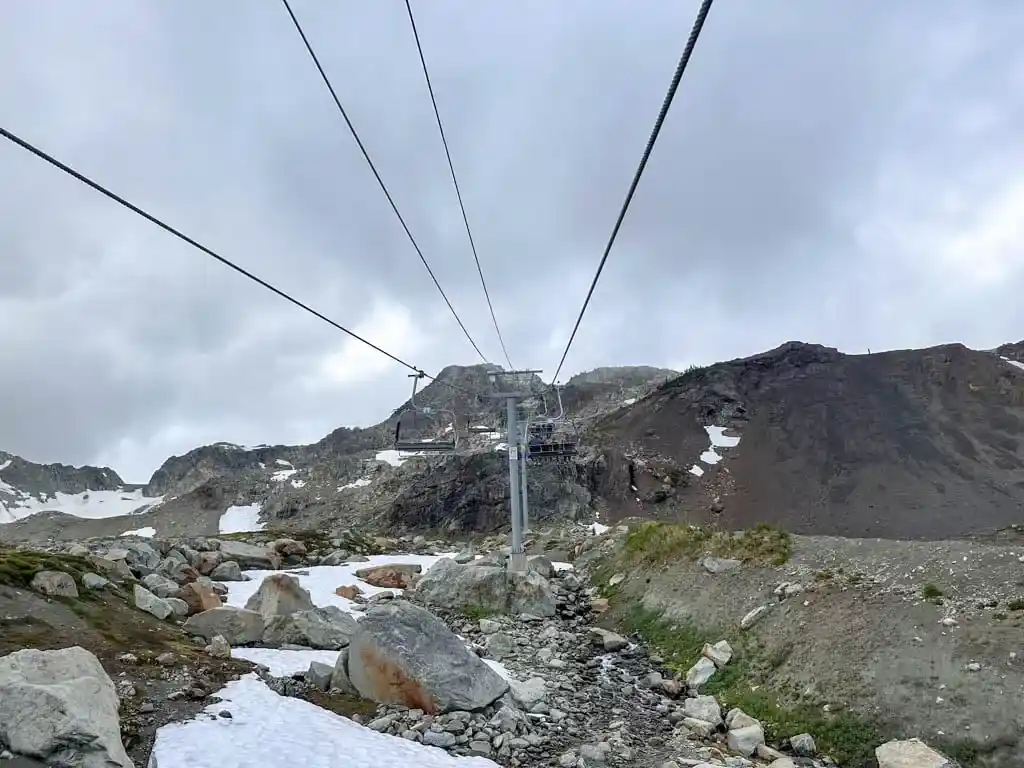 View of rocks, snow, and cliffs from the Peak Chair at Whistler during summer hiking season