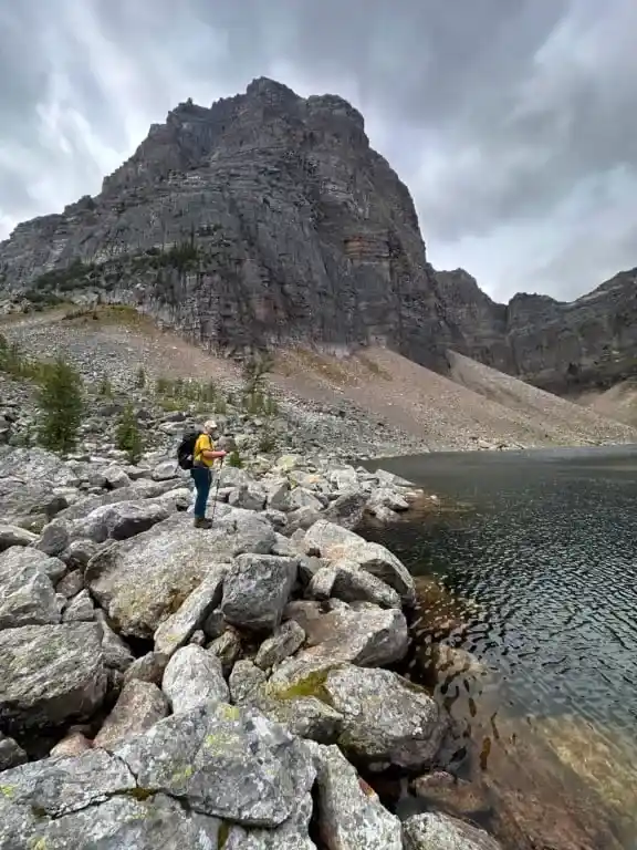 A hiker stands on a rock at Pharaoh Lake.