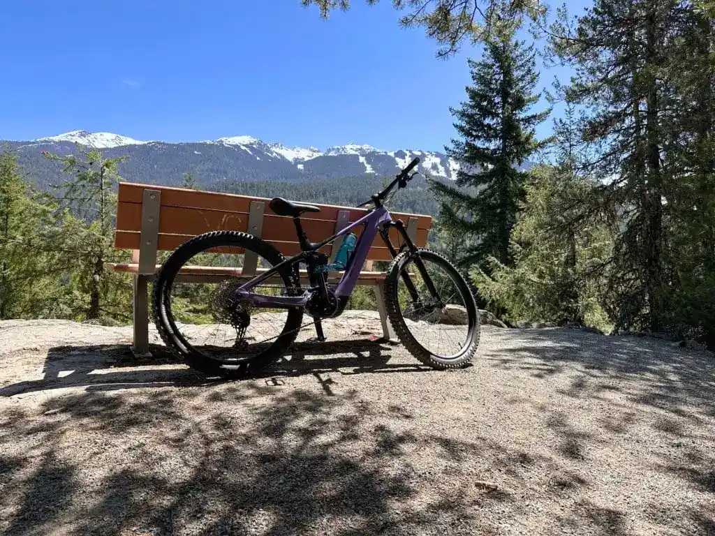 A bike leans against a bench on the Lost Lake mountain bike trails in Whistler