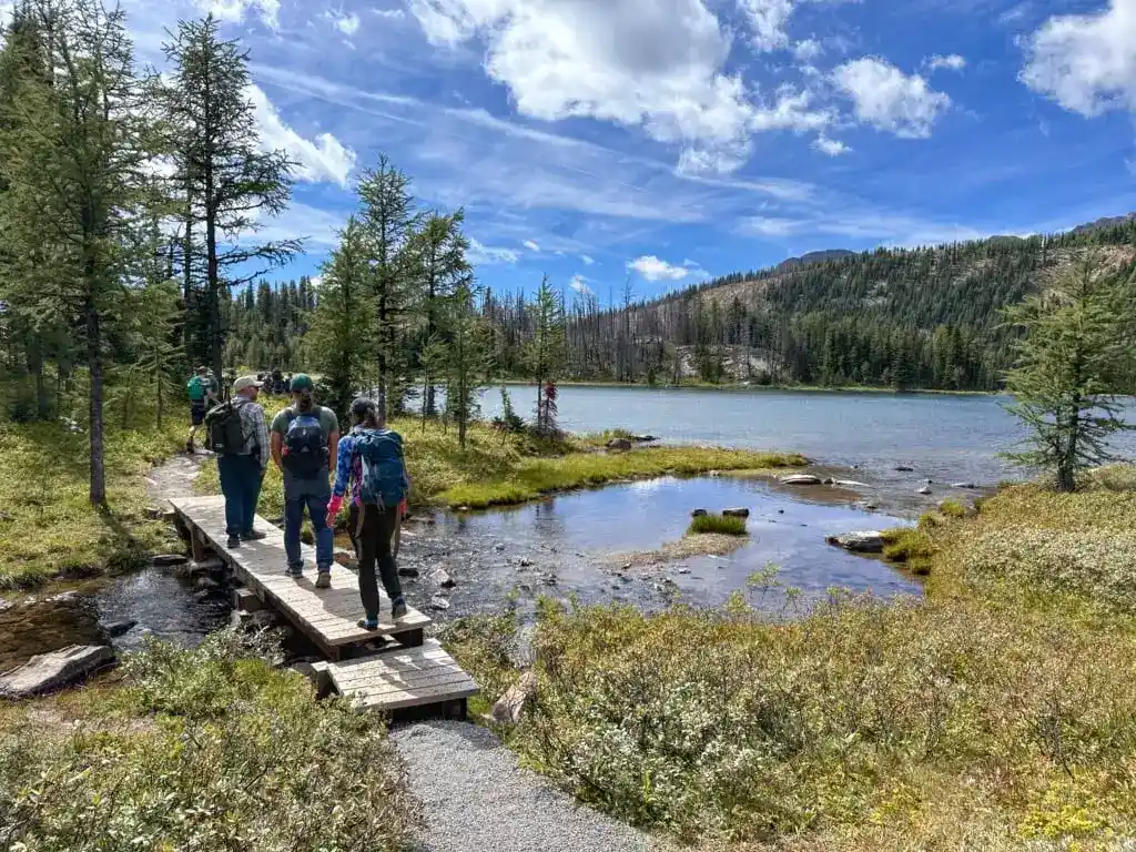Hikers cross a bridge at Grizzly Lake