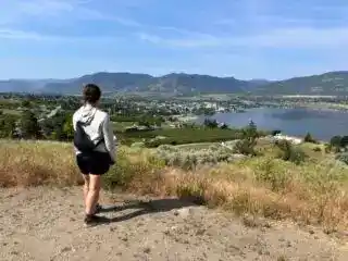 A woman enjoys the view of Penticton from Munson Mountain - one of the best things to to in Penticton in the summer