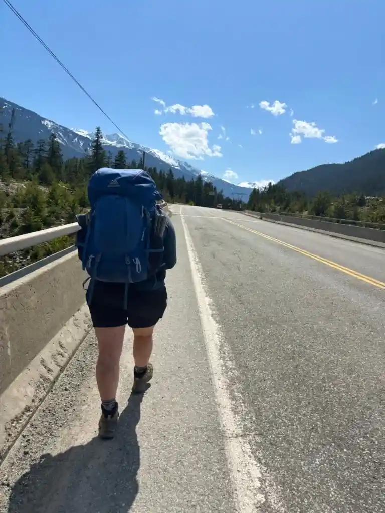A hiker walks on the Sea to Sky Highway